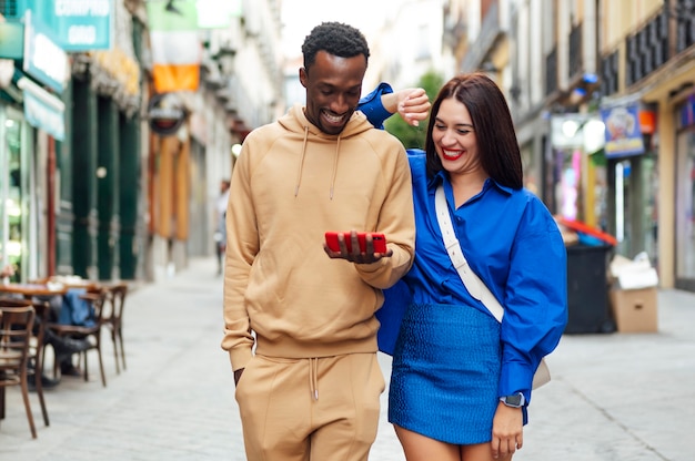 Smiling multiracial couple looking at pictures on phone