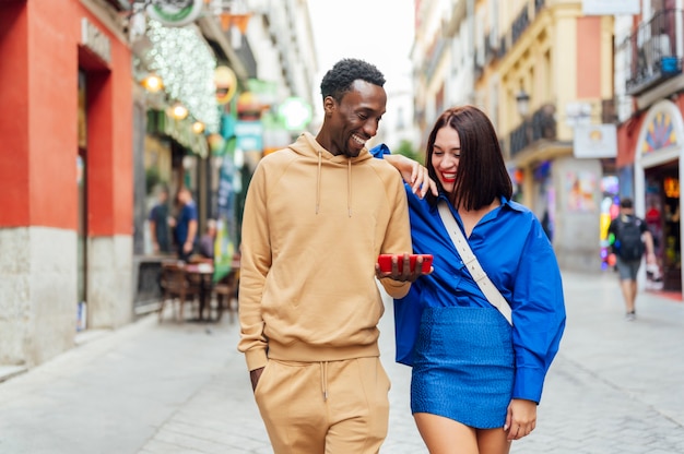 Smiling multiracial couple looking at pictures on phone