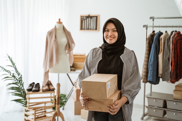 Smiling Muslim woman working in a clothing store