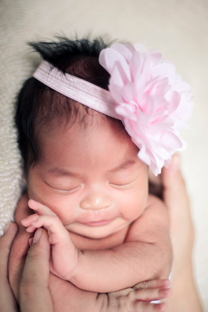 Smiling newborn baby 8 days old hands closeup