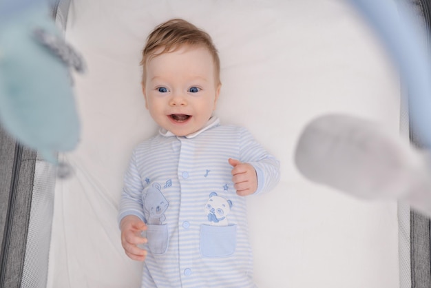 Smiling newborn baby with two little teeth lying on the scene