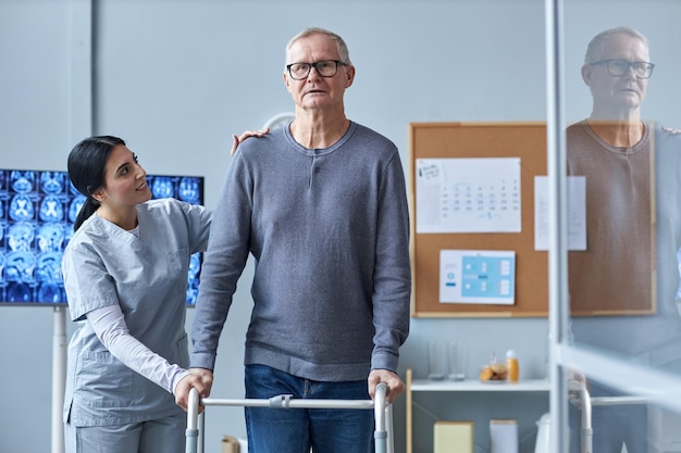 Smiling nurse assisting senior man using mobility walker