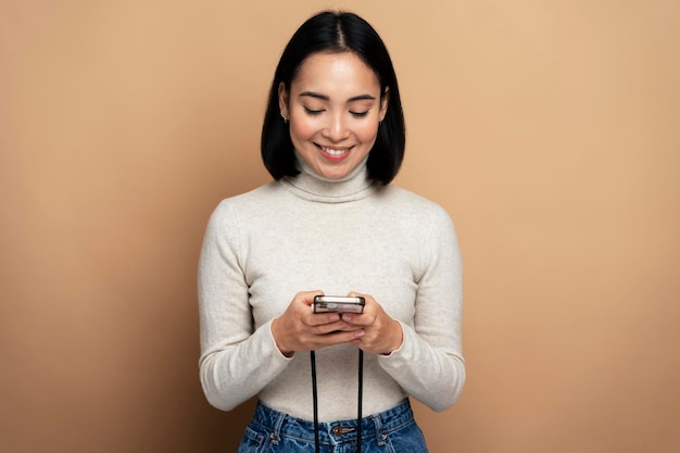 Smiling optimistic woman standing with smartphone in hands