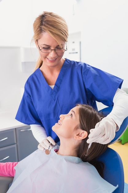 Smiling pediatric dentist with a happy young patient 