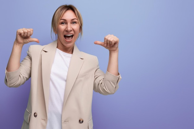 Smiling positive kind european young woman in a jacket on a studio background with copy space for