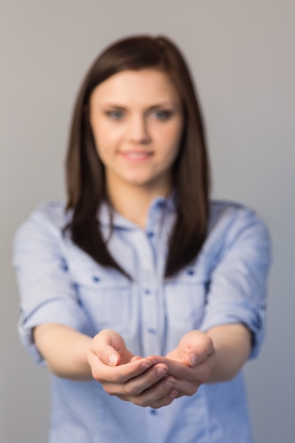 Smiling pretty brunette presenting her empty hands