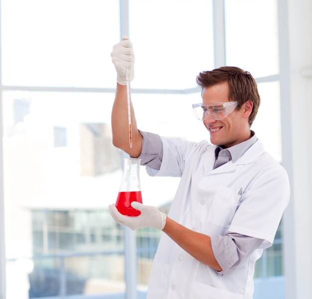 Smiling scientist examinig a test-tube