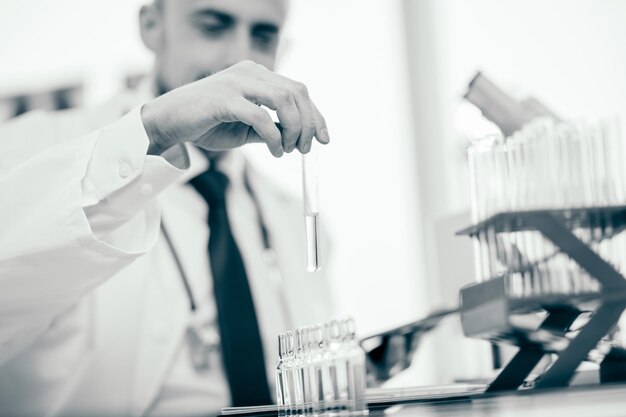 Smiling scientist holds a test tube with a sample of the vaccine