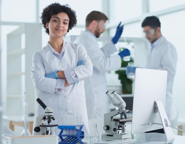 Smiling scientists looking at camera arms crossed in laboratory