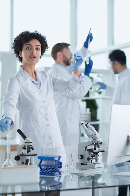 Smiling scientists looking at camera arms crossed in laboratory