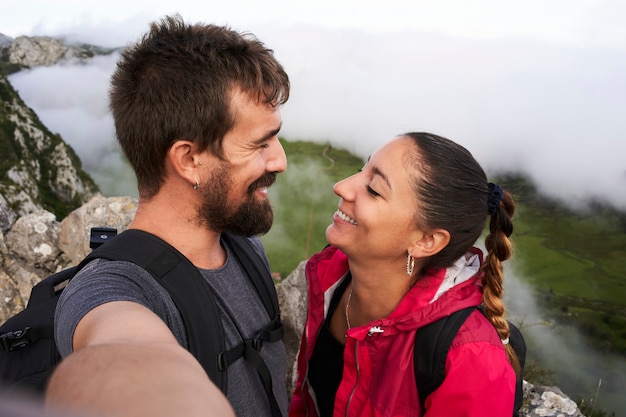 Smiling selfie, young couple on the mountain.