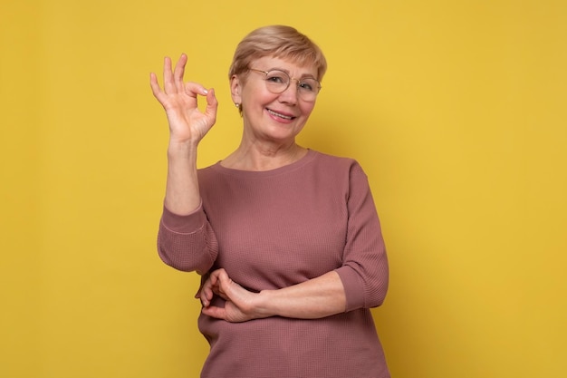 Smiling senior caucasian lady gesturing perfect sign