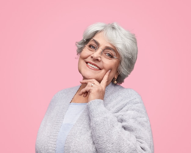 Smiling senior woman touching cheek