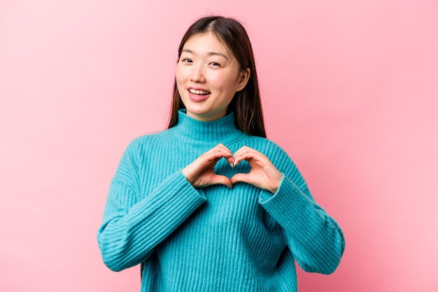 Smiling and showing a heart shape with hands