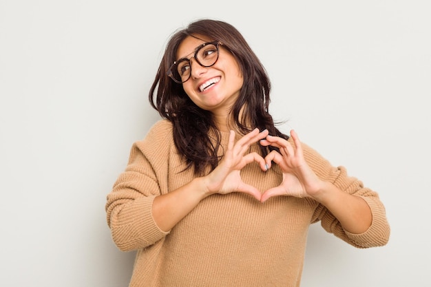 Smiling and showing a heart shape with hands