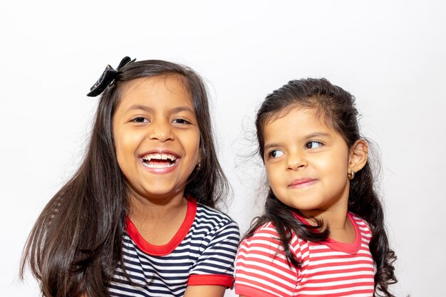 Smiling siblings against white background