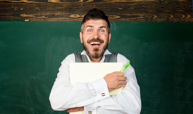 Smiling student in classroom teacher in classroom at elementary school teacher giving lesson to