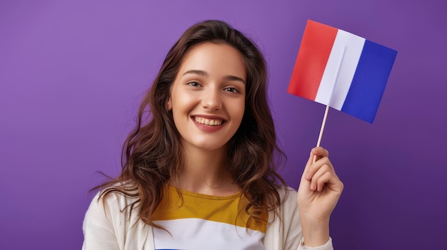 Photo a smiling student holding a small french flag set against a purple background