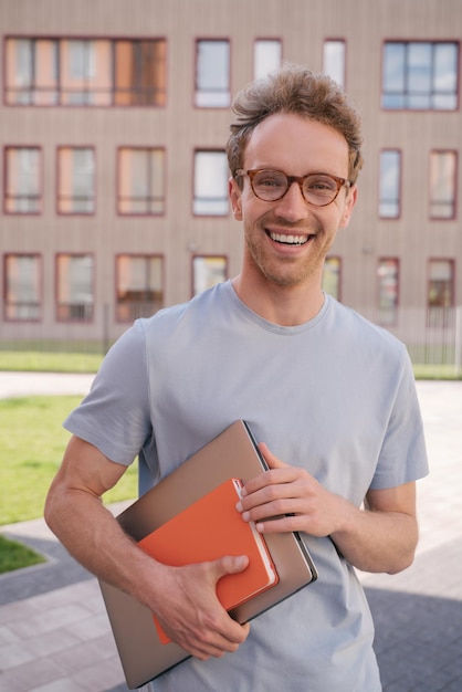 Smiling student wearing eyeglasses looking at camera in university campus Education concept