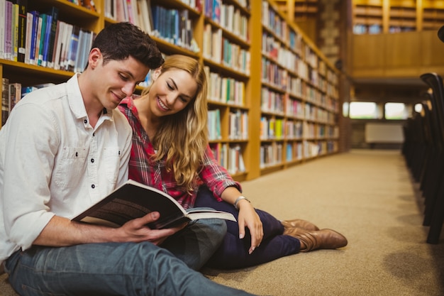 Smiling students working together on floor in library 