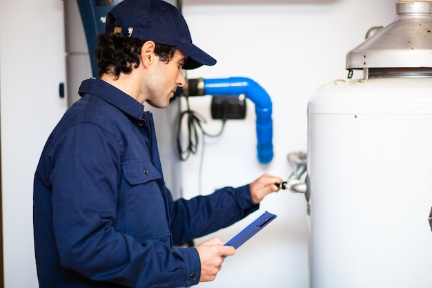 Smiling technician repairing an hotwater heater