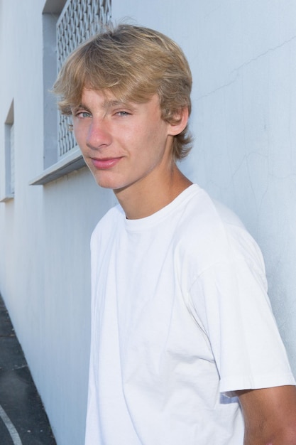 Photo smiling teen boy 14-16 year old having fun outdoors. looking at camera. teenagerhood. positive mood