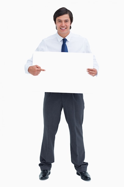 Smiling tradesman pointing at blank sign in his hands