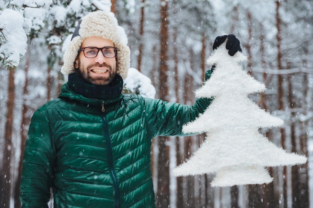 Smiling unshven middle aged male ears warm cap and green anorak