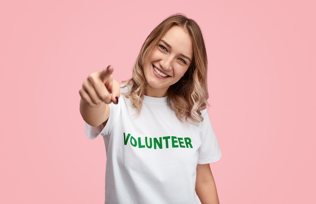 Smiling volunteer pointing forwards