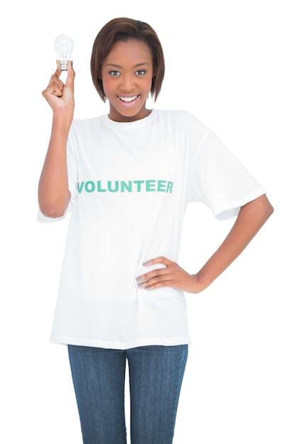 Smiling volunteer woman holding light bulb