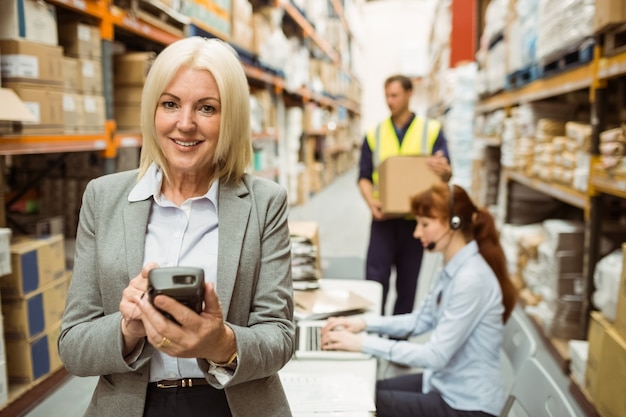 Smiling warehouse manager using handheld 