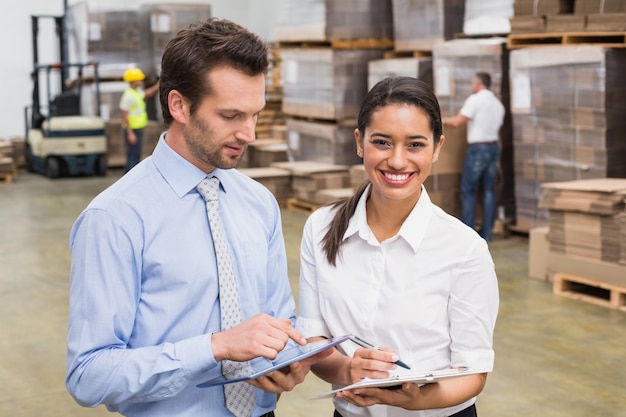 Smiling warehouse managers working together