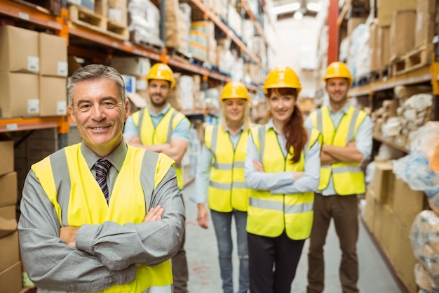 Smiling warehouse team with arms crossed