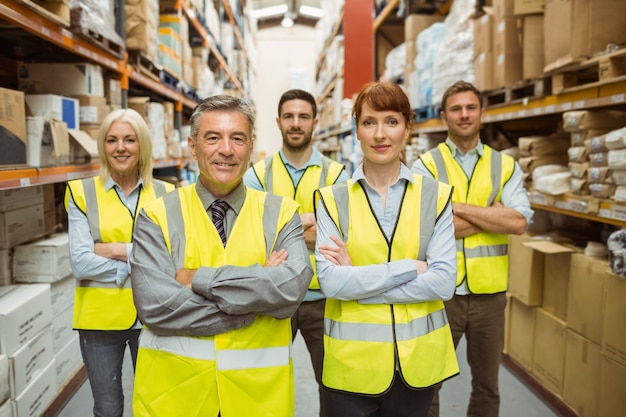 Smiling warehouse team with arms crossed