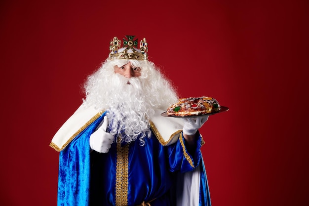 Smiling Wise Man holding a quotroscon de reyesquot in his hand on a red background