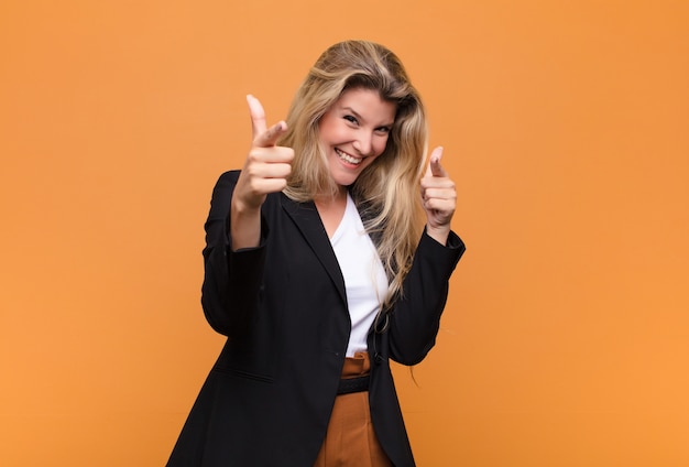 smiling with a positive, successful, happy attitude pointing, making gun sign with hands