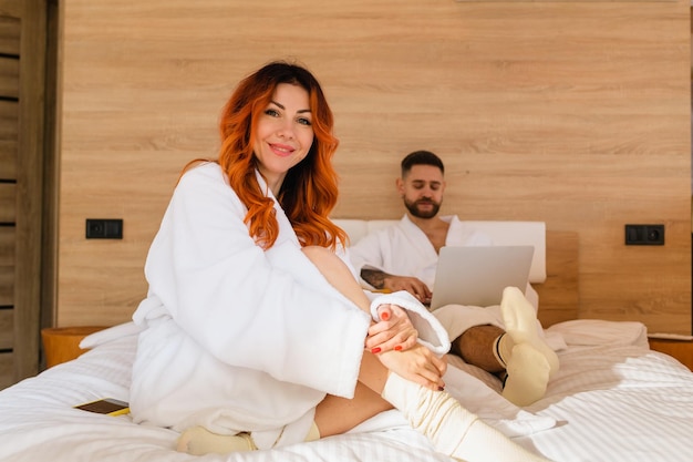 Smiling woman in a bathrobe sitting on bed