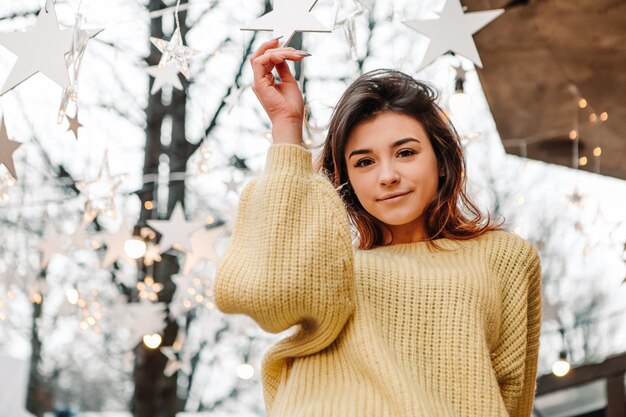 Smiling woman celebrating dressed warm sweater posing outside