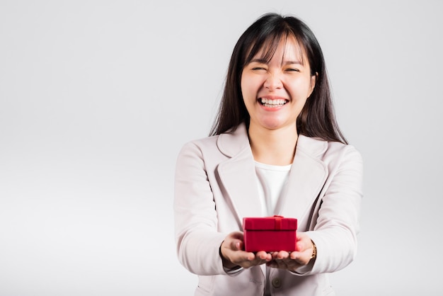 Smiling woman confidence holding red gift box on hands palm isolated white background