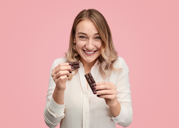 Smiling woman dividing chocolate