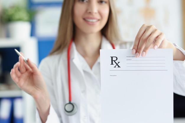 Smiling woman doctor hold prescription recipe in one hand and pen in another