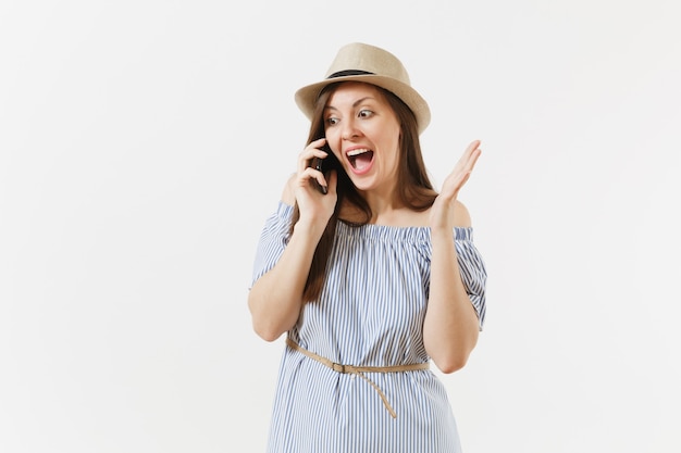 Smiling woman dressed blue dress, hat talking on mobile phone, conducting pleasant conversation isolated on white background. People, sincere emotions, lifestyle concept. Advertising area. Copy space.