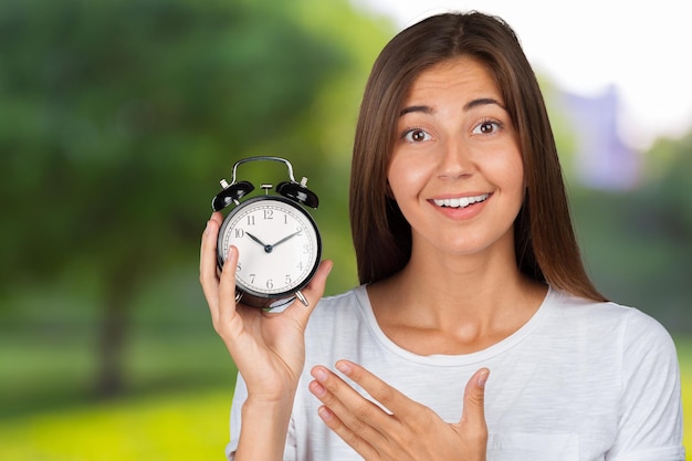 Smiling woman holding alarm watch