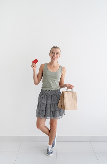 Smiling woman holding eco friendly shopping bags and credit card