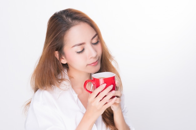 Smiling woman holding red coffee cup.