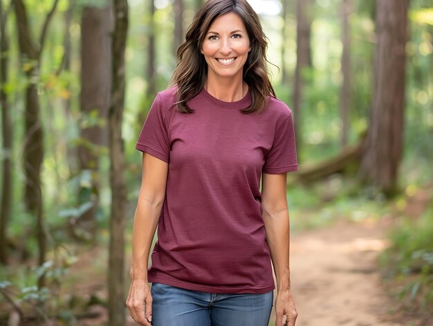 Photo smiling woman in maroon shirt standing in the woods with a dog