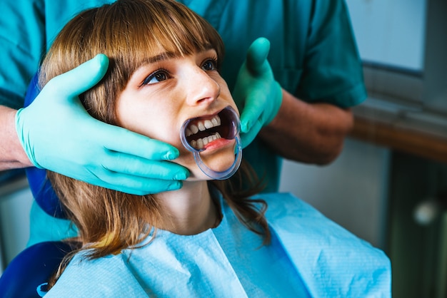 Smiling woman mouth under treatment at dental clinic