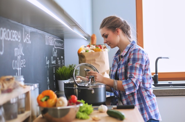 Smiling woman online shopping using tablet and credit card in kitchen