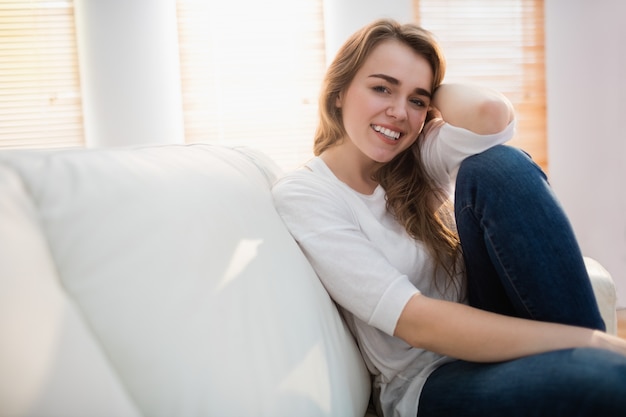 Smiling woman posing on the couch in the living room