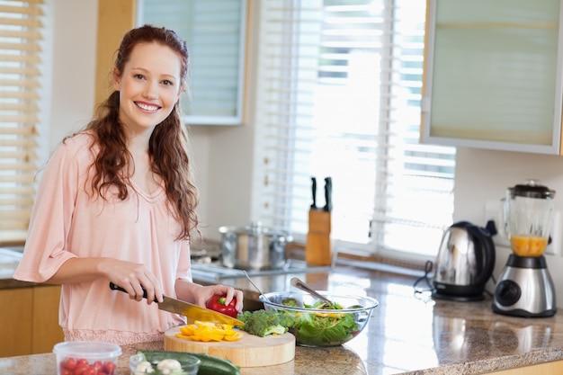 Smiling woman preparing salad